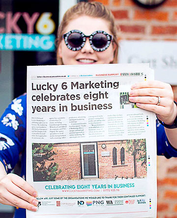 Terri Juniper holding up the business Lancashire news paper